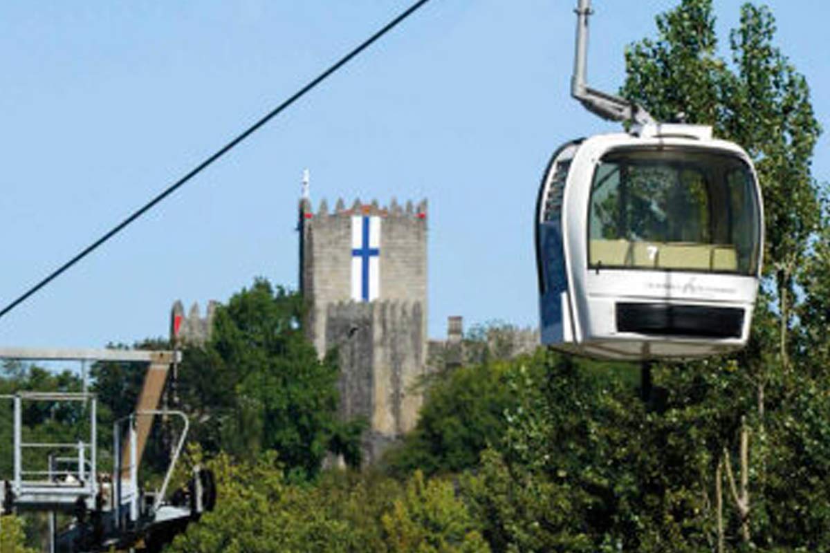 imagem de uma cabine do teleférico com a torre do Castelo de Guimarães ao fundo.