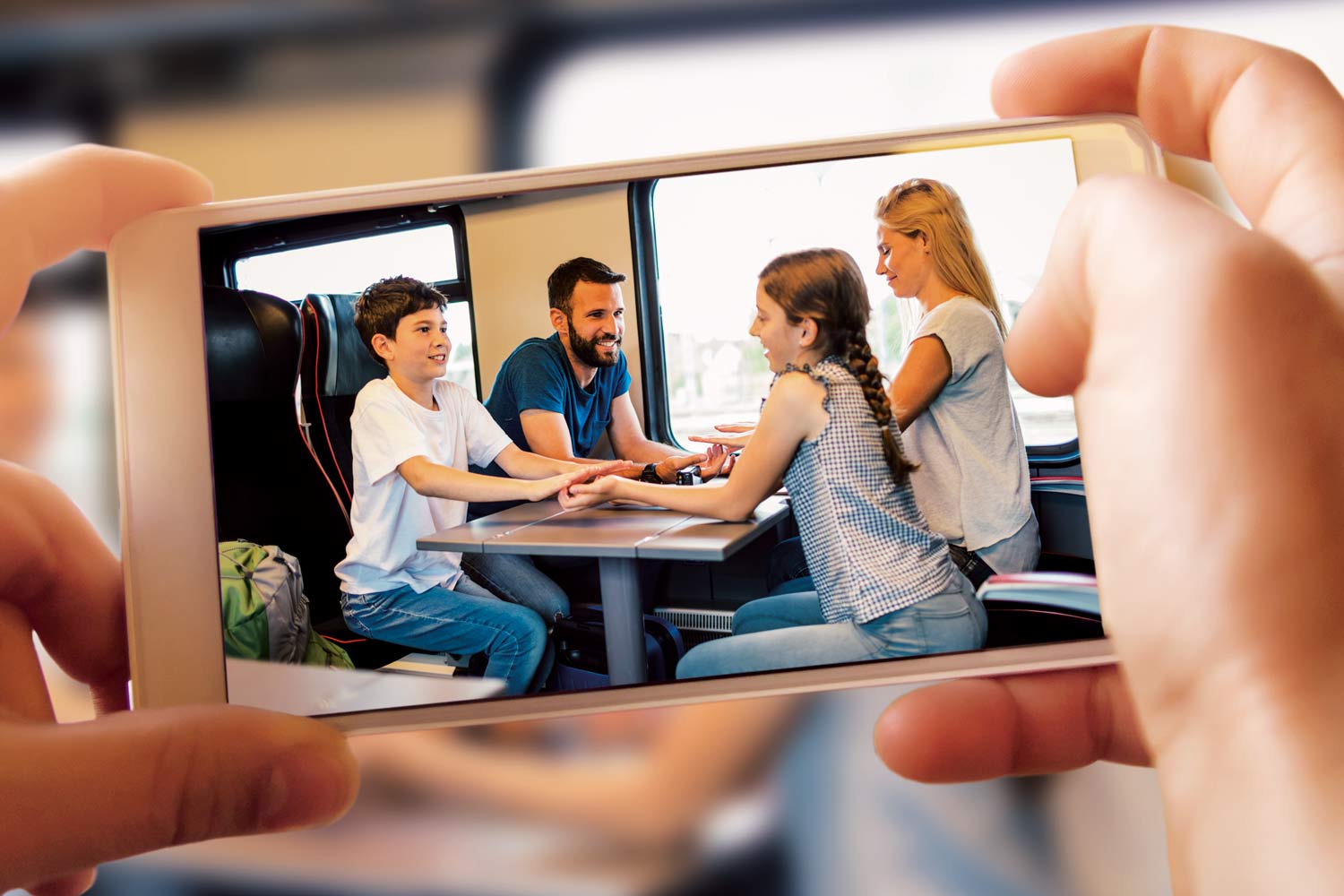 Família de pais, filha e filho, a bordo de comboio em 4 lugares de mesa.