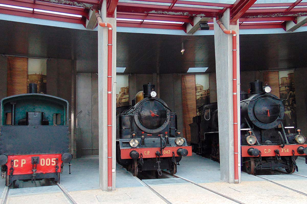 Vista frontal de 3 locomotivas históricas no Museu Nacional Ferroviário.