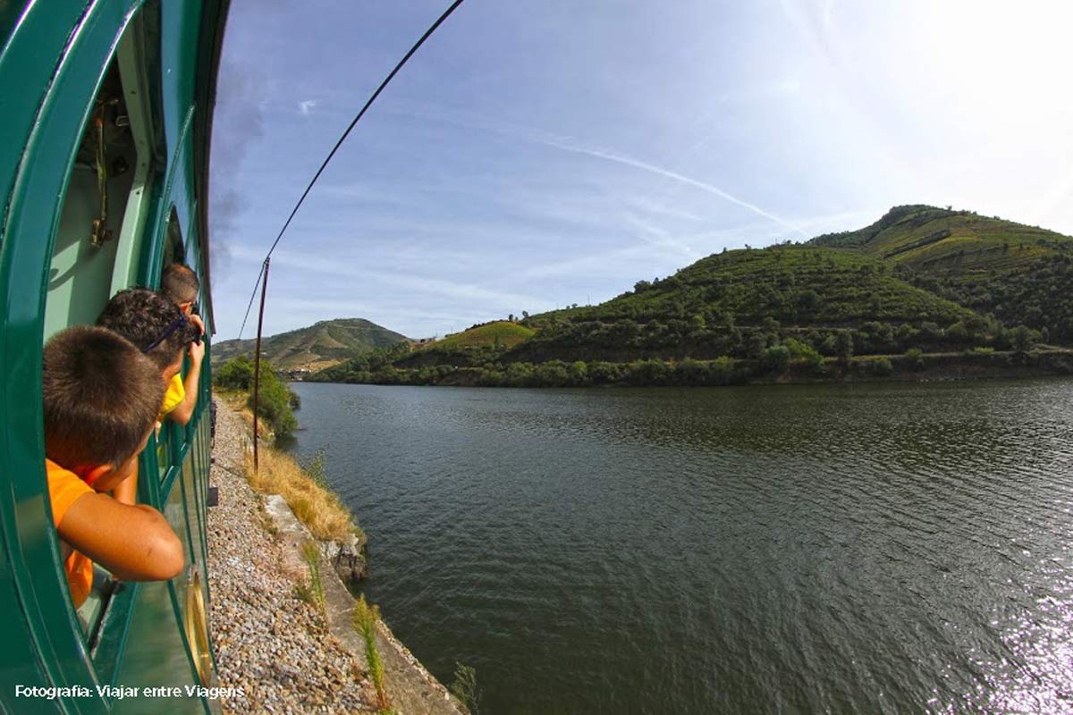 pessoas à janela do comboio a ver o rio Douro