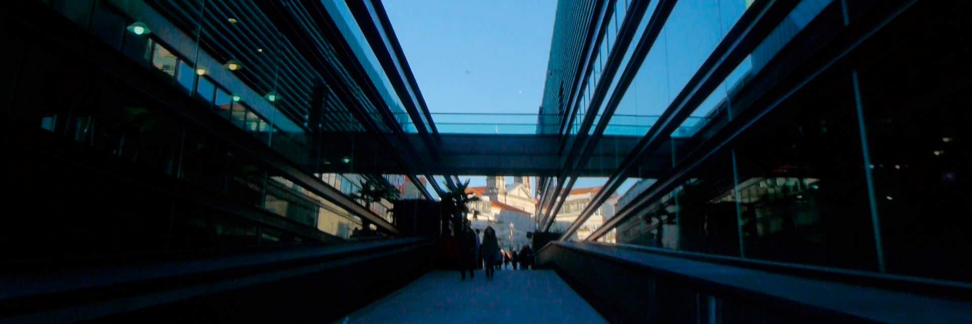 Modern building in Vigo contrasts with an old church in the background.