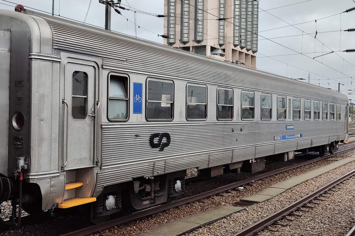 2nd class Sorefame coach with gray livery stopped at one of the station lines.