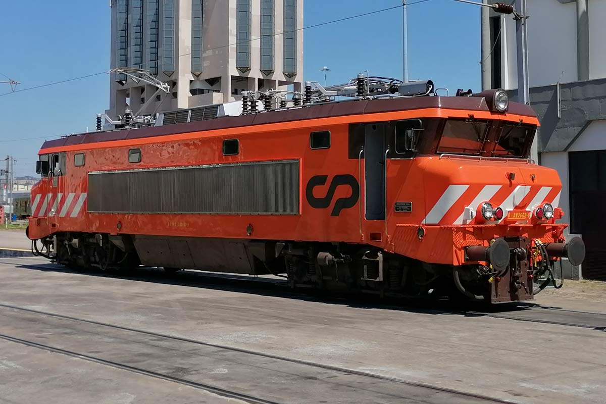 CP 2600 series electric locomotive with orange livery and white stripes at de front stopped in one of the station lines.