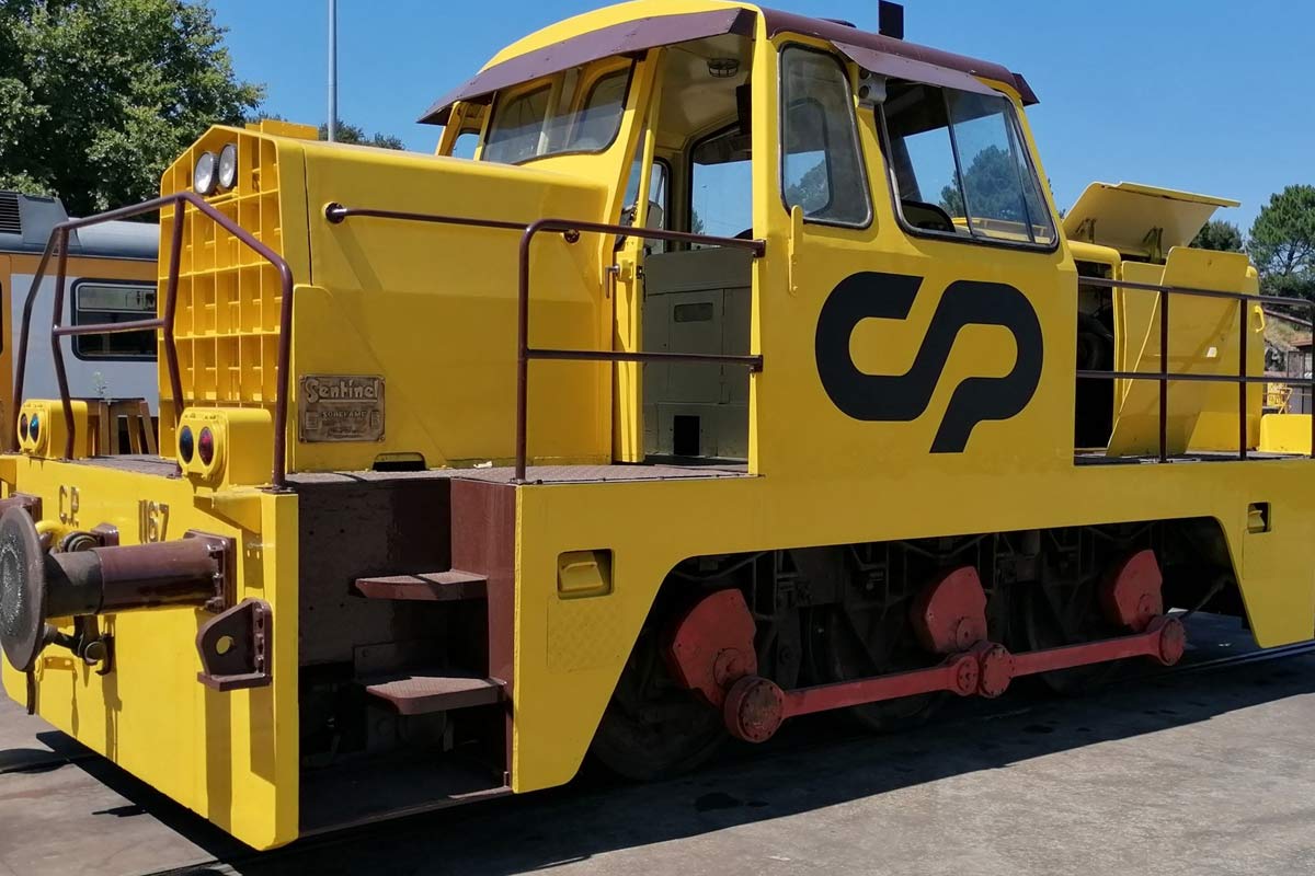 CP 1150 series shunting locomotive with yellow livery parked near the workshop.