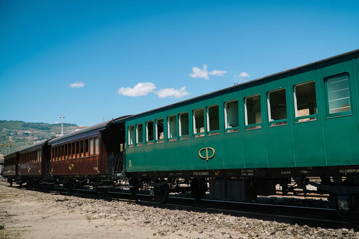 Iberian gauge wooden carriages with green and brown livery, stopped in one of the station lines.