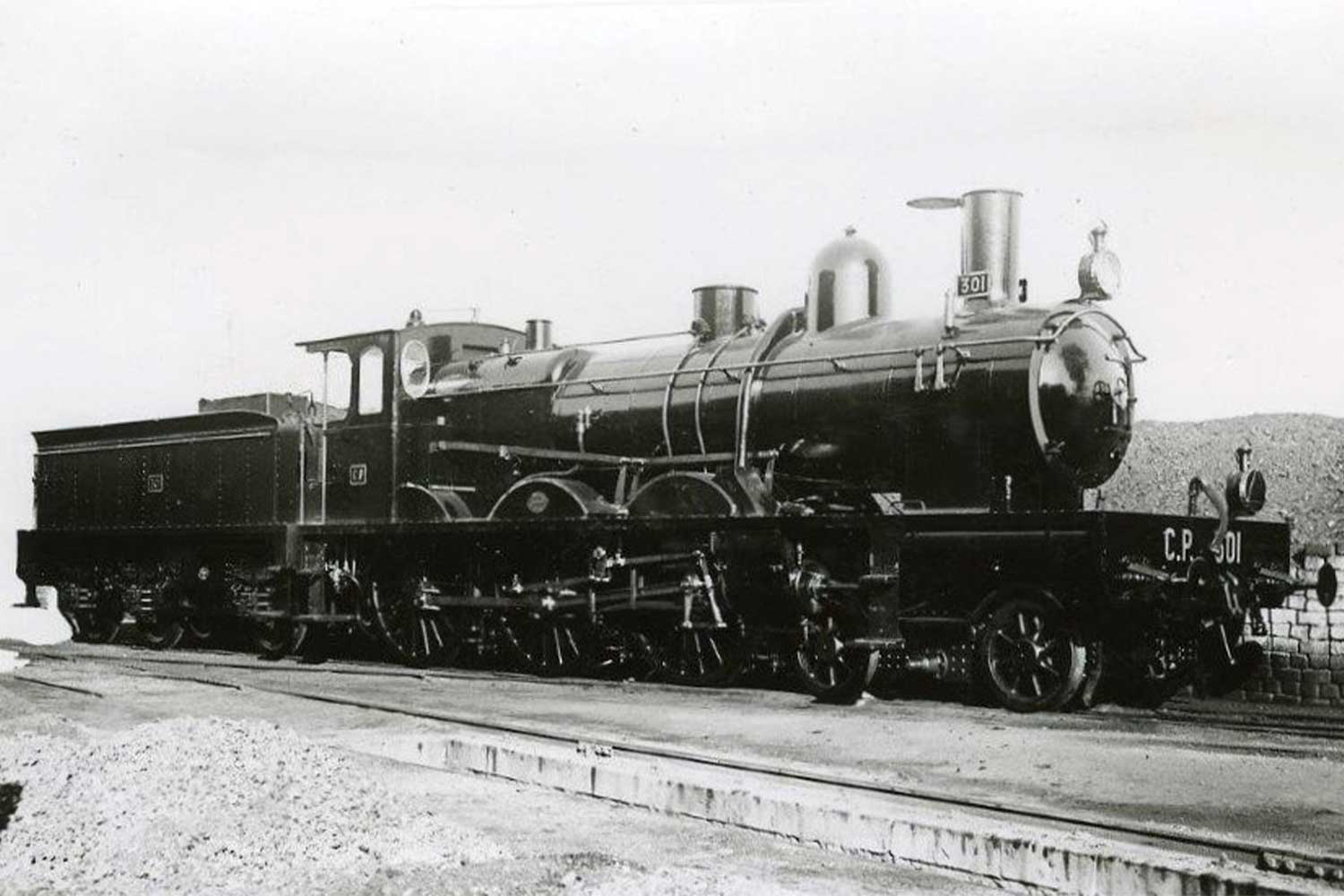 Black CP 301 steam engine stopped at a station.