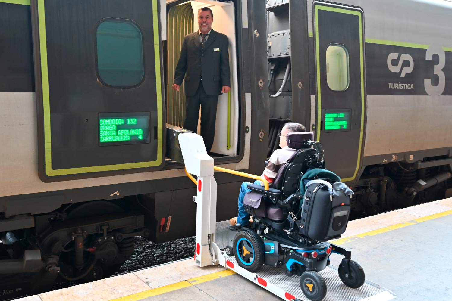 Pessoa em cadeira de rodas na rampa de acesso ao comboio Alfa Pendular