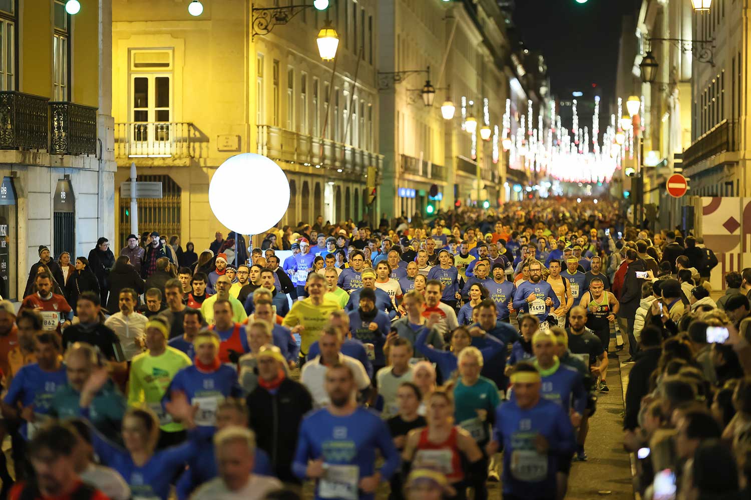 Pessoas a correr na rua à noite.