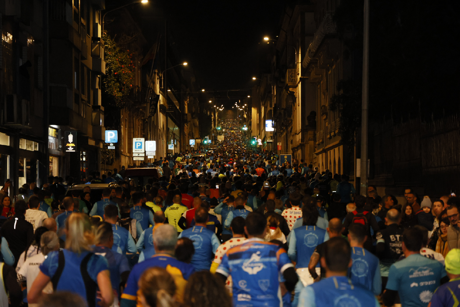 Pessoas a correr na rua à noite.