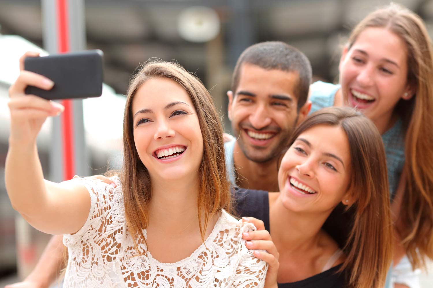  Four young people taking a selfie.
      