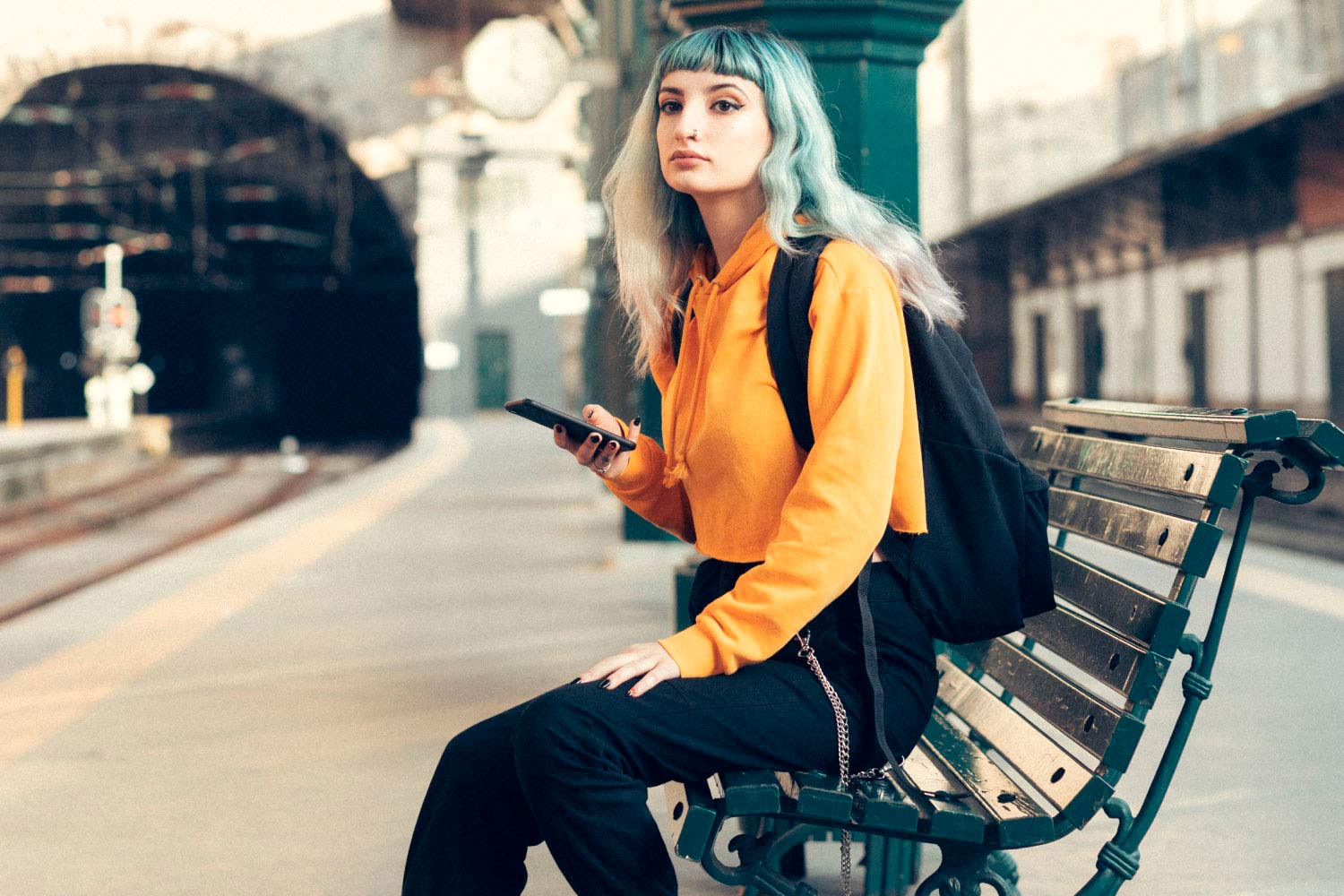 Jovem sentada em banco da Estação de Porto São Bento.