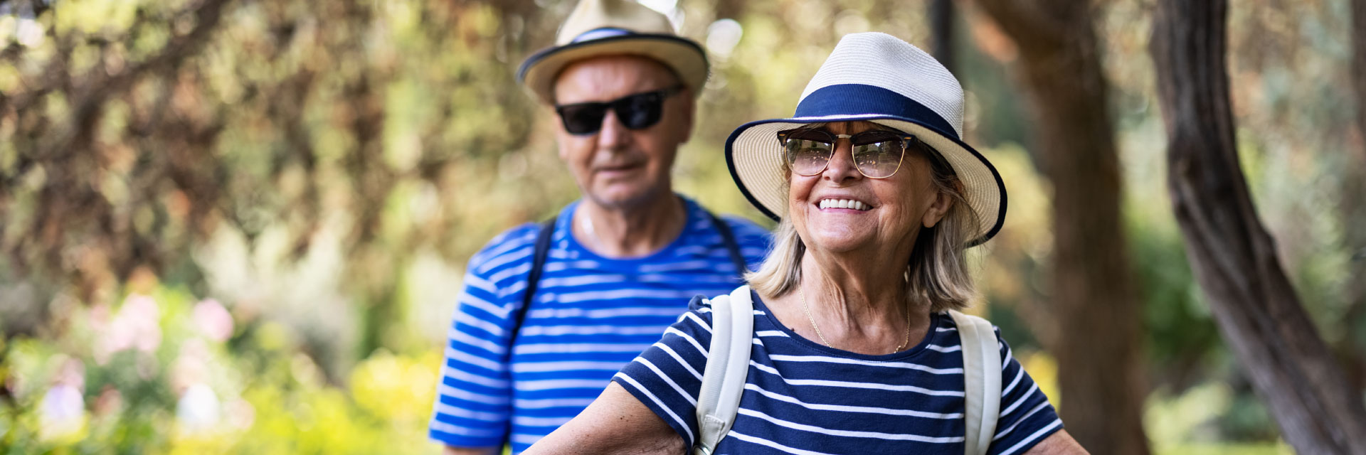 Casal senior abraçado e sentado em banco de jardim.
