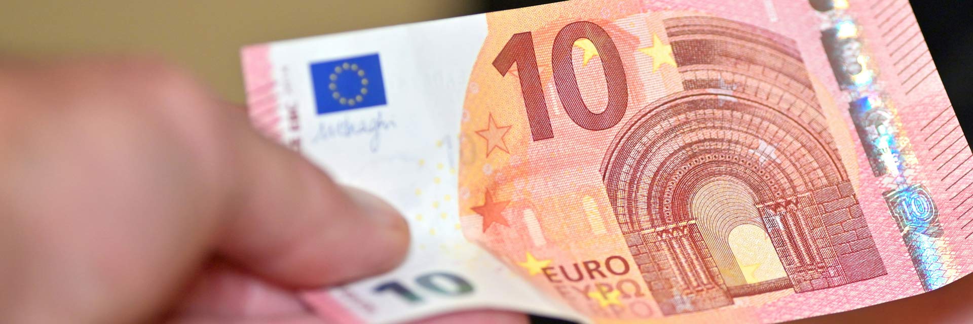 Nota de 10 € na mão.
