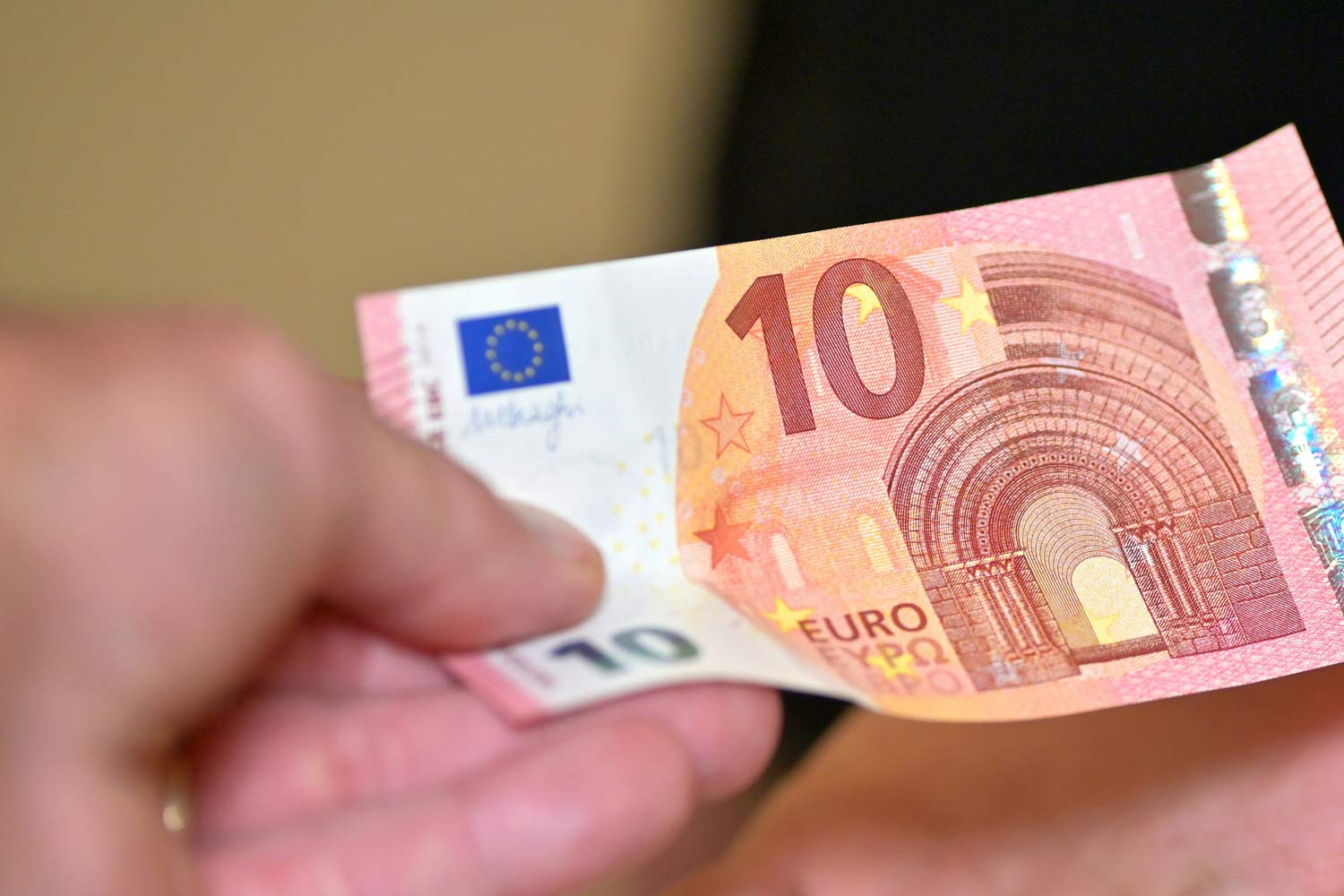 Nota de 10 € na mão.