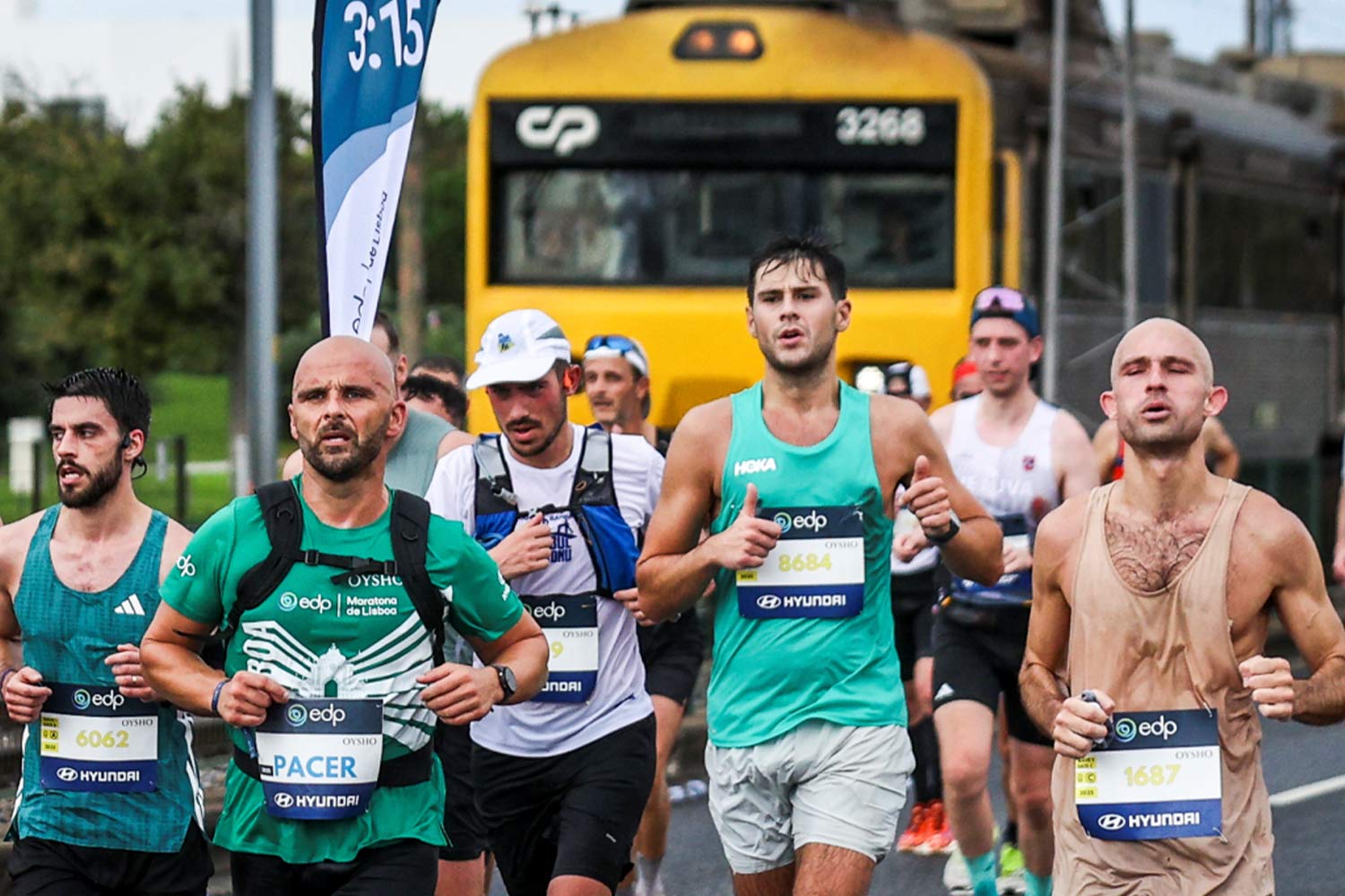 Pessoas a correr junto à Linha de Cascais com o comboio a passar.