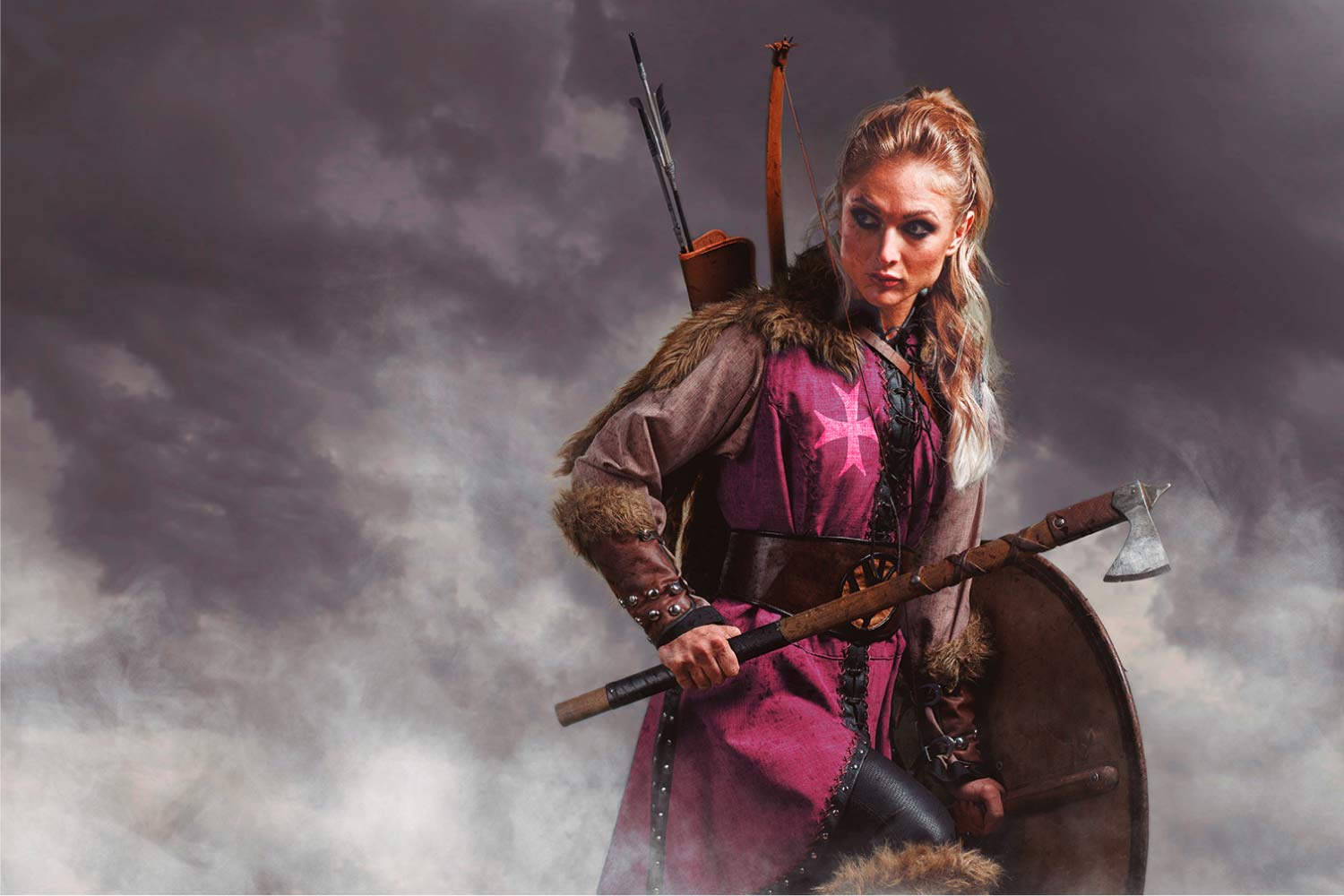A colour image of a woman in medieval dress, holding an axe and a shield.