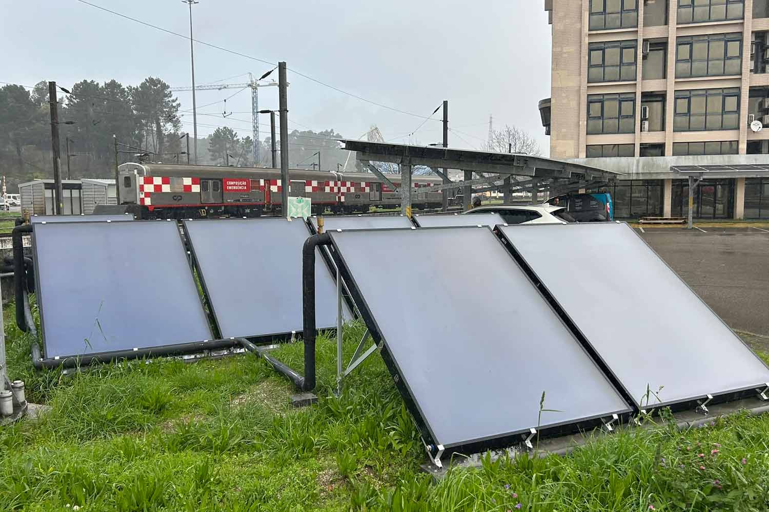 Painéis solares junto ao edifício em Contumil e ao fundo o comboio emergência.